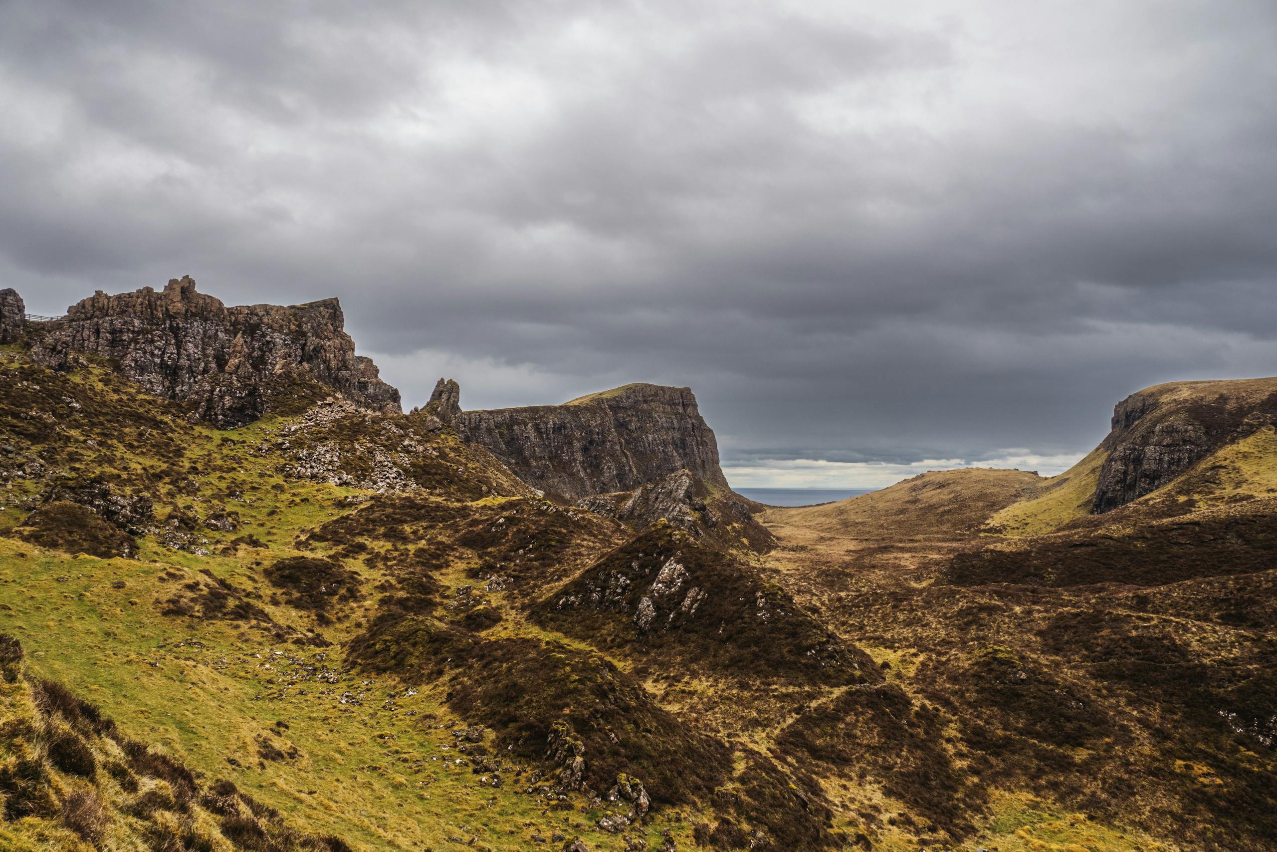 A breathtaking view of Scotland's rugged highlands with dramatic clouds overhead.